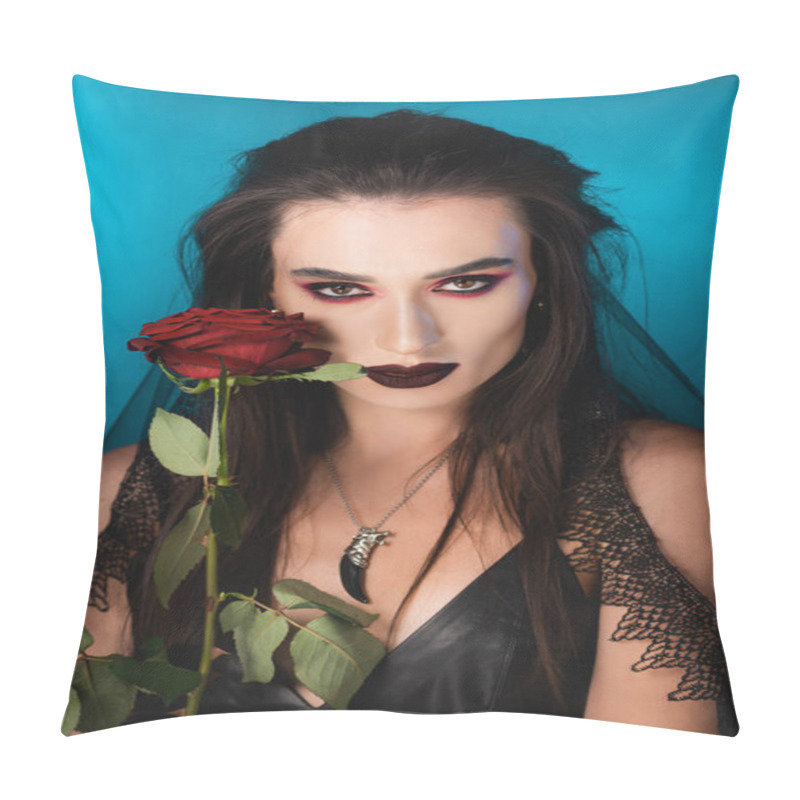 Personality  young brunette woman with dark makeup near red rose on blue pillow covers
