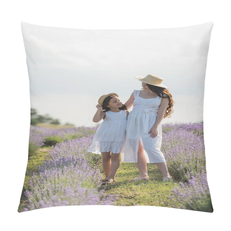 Personality  girl and mom in summer dresses and straw hats smiling at each other in blooming meadow pillow covers