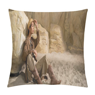Personality  Full Length Of Young Archaeologist Sitting On Sand Near Stone And Adjusting Safari Hat, Banner Pillow Covers