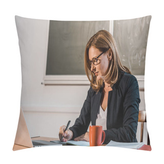 Personality  Female Teacher Sitting At Computer Desk And Writing In Notebook During Lesson In Classroom  Pillow Covers