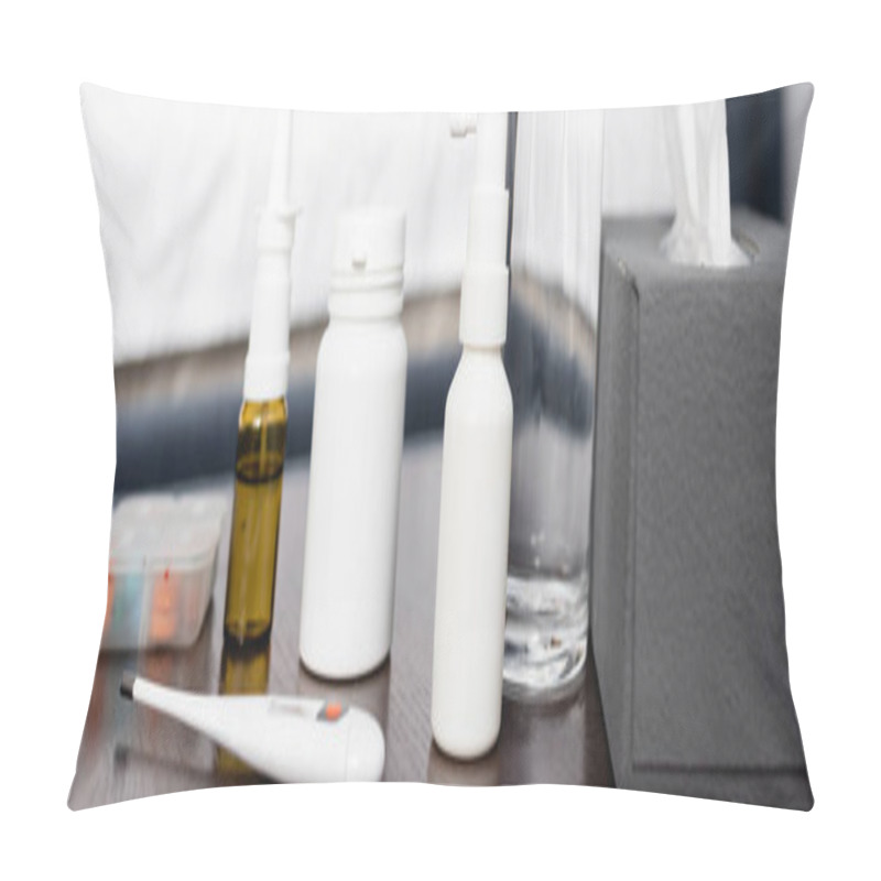 Personality  bedside table with nasal and throat sprays, thermometer, paper napkins and glass of water, banner pillow covers