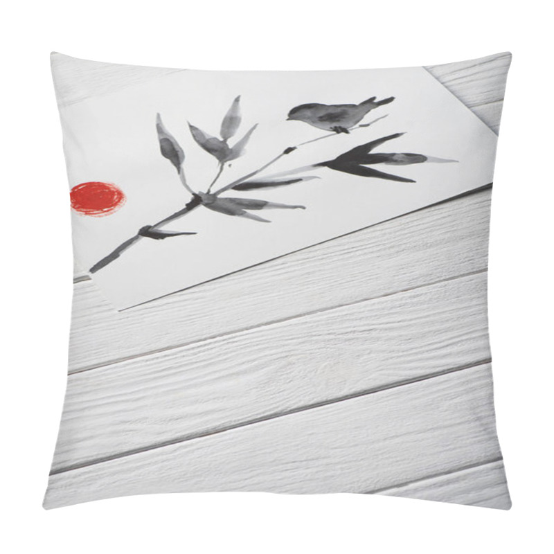 Personality  Top view of paper with japanese painting with bird on branch with leaves and sun on wooden background pillow covers