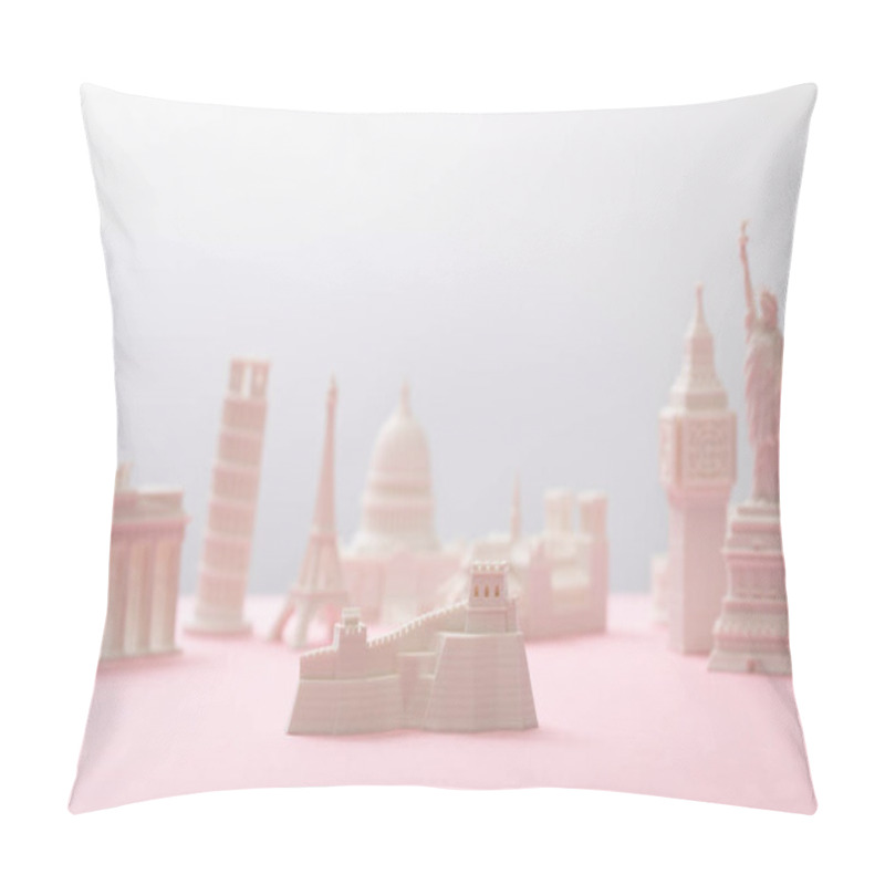 Personality  selective focus of great wall figurine near statuettes on grey and pink  pillow covers