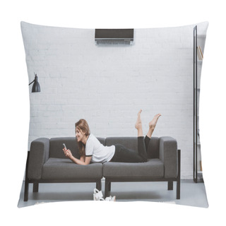 Personality  Happy Young Woman Using Smartphone While Lying On Sofa Under Air Conditioner Hanging On Wall Pillow Covers
