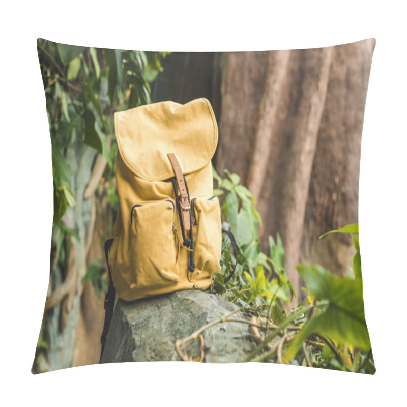 Personality  close-up shot of vintage yellow backpack on rock in jungle pillow covers