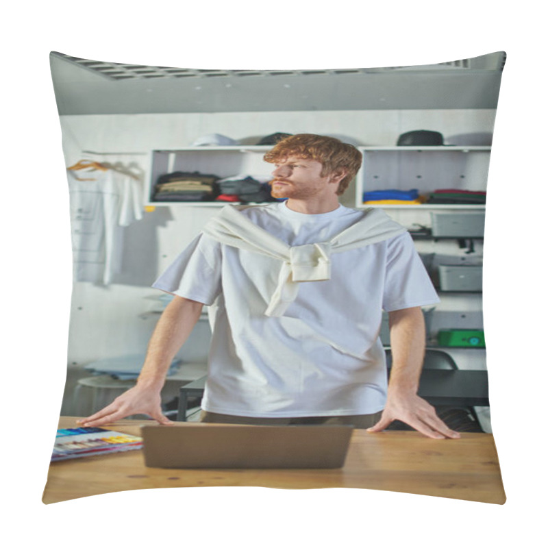 Personality  Young Redhead Craftsman In Casual Clothes Looking Away While Standing Near Laptop And Cloth Samples On Table In Blurred Print Studio, Self-made Success Concept  Pillow Covers