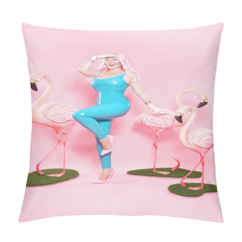 Personality  cute plump girl dressed in a shiny blue latex swimsuit posing with a big Flamingo on a pink studio background pillow covers