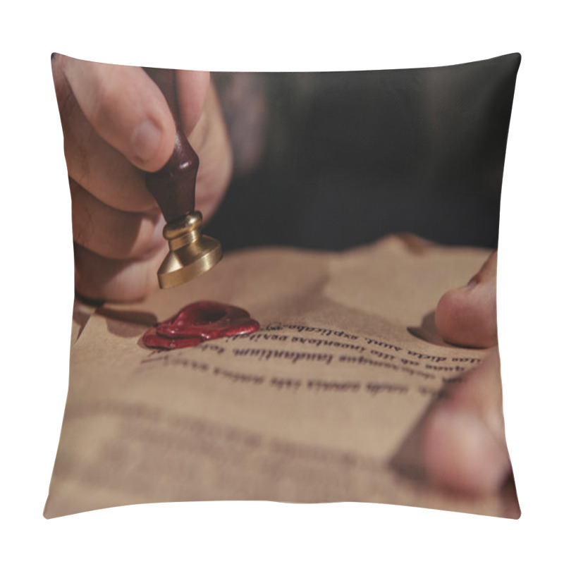 Personality  close up view of wax seal in hand of cropped monk near manuscript on black background pillow covers