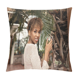 Personality  Portrait Of Stylish Young African American Woman With Braces Posing In Knitted Top Touching Brunch Of Palm Tree And Looking At Camera In Indoor Garden, Fashionista Posing Amidst Tropical Flora  Pillow Covers