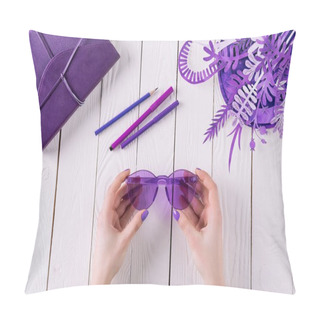 Personality  Cropped Shot Of Woman Holding Purple Eyeglasses Over Table Pillow Covers