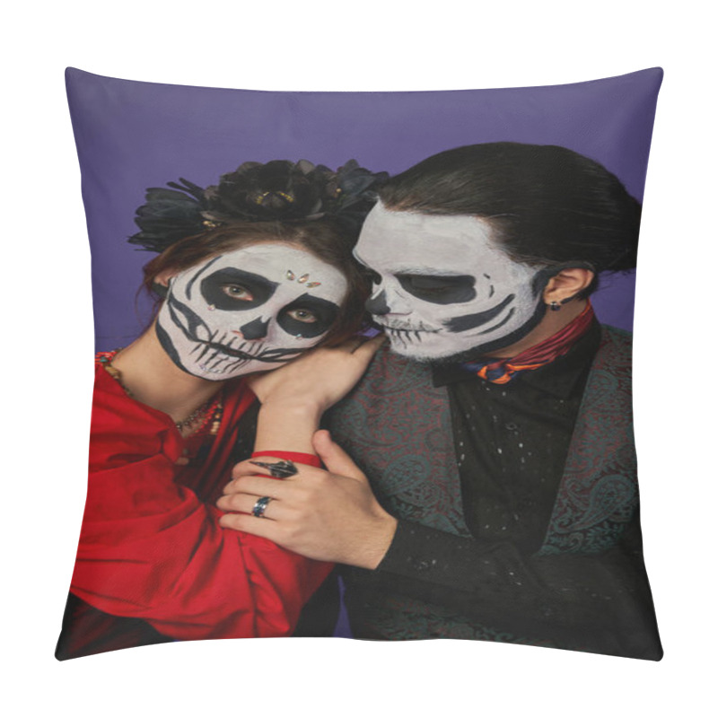 Personality  woman in skull makeup and black wreath leaning on shoulder of man and looking at camera on blue pillow covers