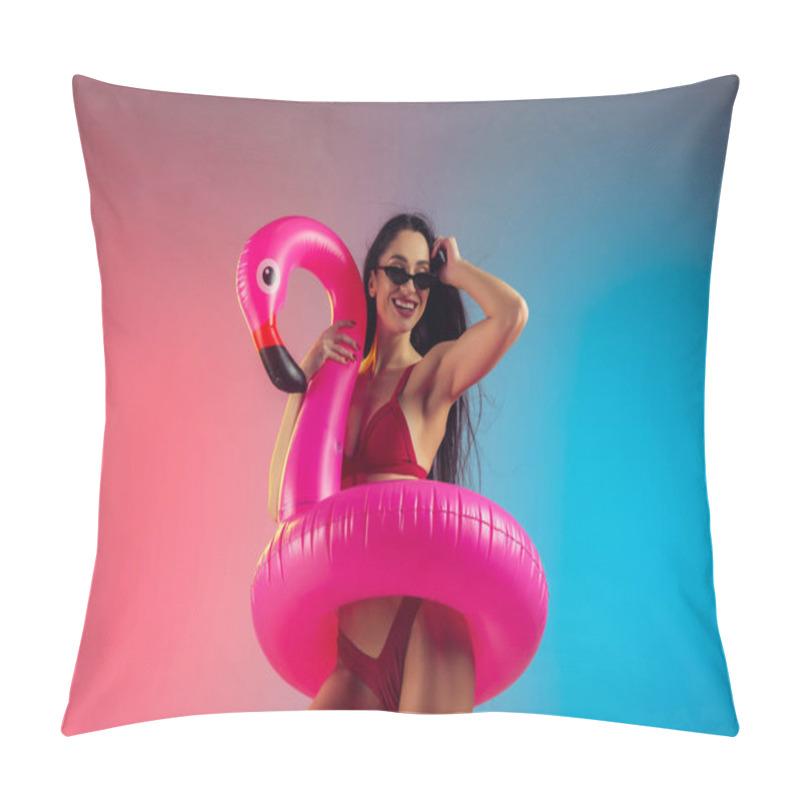 Personality  Fashion portrait of young fit and sportive woman with rubber flamingo in stylish red swimwear on gradient background. Perfect body ready for summertime. pillow covers