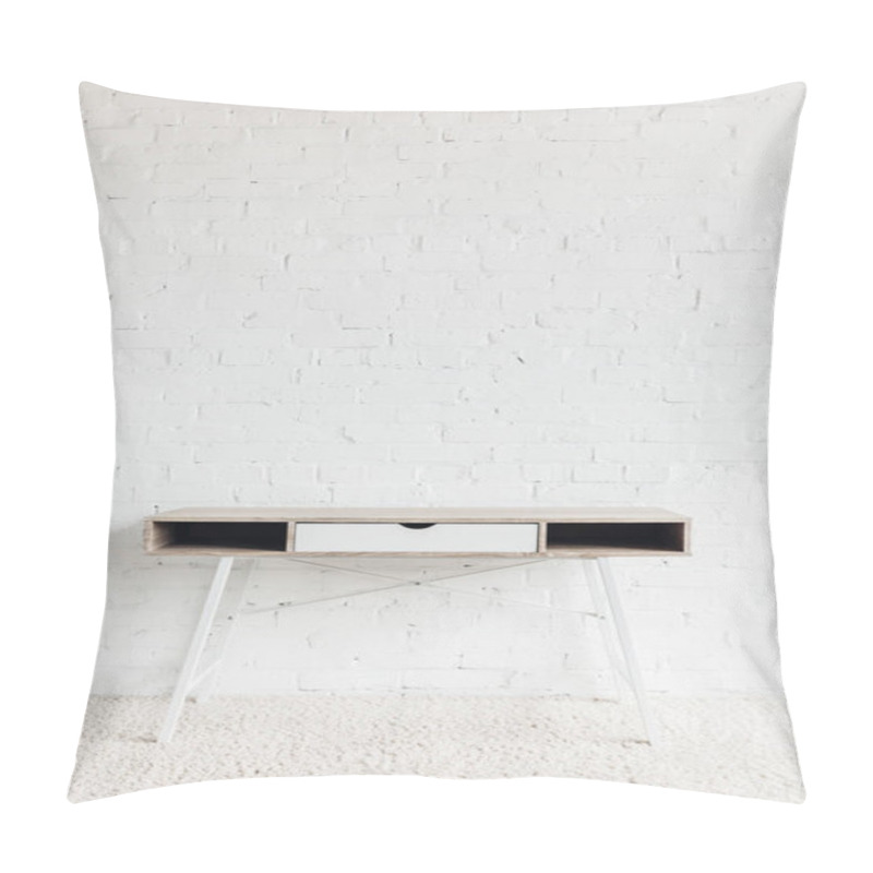 Personality  empty work table in front of white brick wall, mockup concept pillow covers