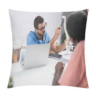 Personality  Physiotherapist In Eyeglasses Pointing At Spine Model Near Blurred African American Patient Pillow Covers
