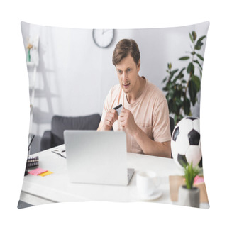 Personality  Selective Focus Of Man Holding Credit Card And Looking At Laptop Near Football And Stationery On Table, Concept Of Earning Online Pillow Covers