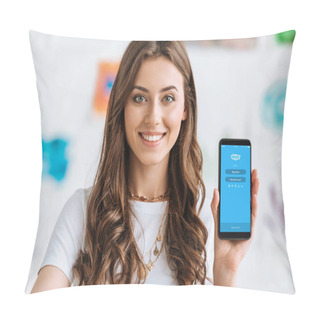 Personality  KYIV, UKRAINE - APRIL 17, 2019: Happy Smiling Girl Showing Smartphone With Skype App On Screen And Looking At Camera. Pillow Covers