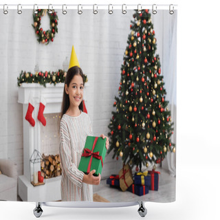 Personality  Happy Girl In Party Cap Holding Gift Box Near Blurred Christmas Tree And Fireplace At Home  Shower Curtains