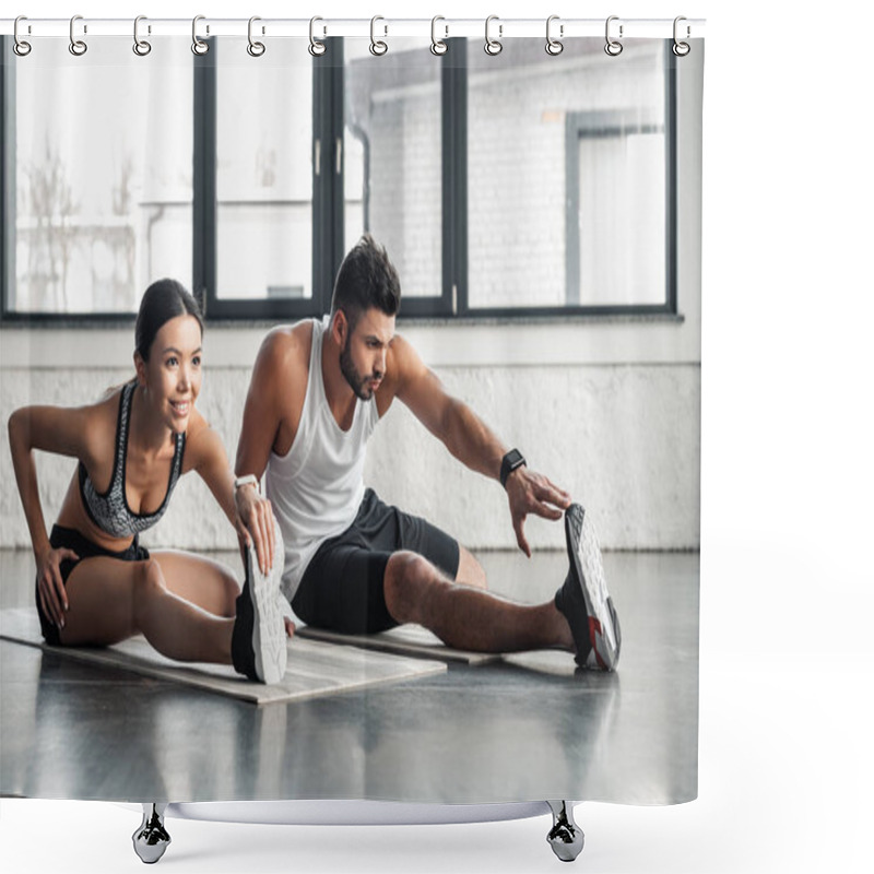 Personality  athletic young man and woman stretching legs on yoga mats in gym shower curtains