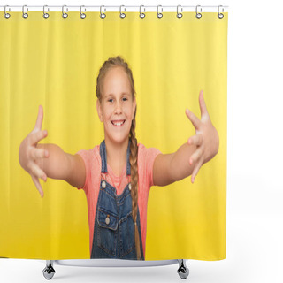 Personality  Portrait Of Excited Generous Little Girl With Braid In Denim Overalls Opening Hands Wide To Give Free Hugs, Ready To Embrace Friend, Looking Hospitable Kind. Studio Shot Isolated On Yellow Background Shower Curtains
