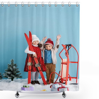 Personality  Girl In Winter Outfit Holding Skis Near Brother With Hands Above Head Standing Near Sleight And Presents On Snow Isolated On Blue  Shower Curtains