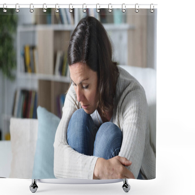 Personality  Pensive sad adult woman looking down sitting on the sofa in the living room at home shower curtains