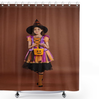 Personality  Happy Girl In Halloween Costume And Pointed Hat Standing With Candy Bucket On Brown Background Shower Curtains