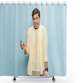 Personality  Disgusted Young Man In Yellow Shirt Holding Bottle With Perfume And Sticking Out Tongue On Blue Shower Curtains