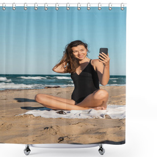 Personality  Happy Young Woman In Swimsuit Taking Selfie On Smartphone While Sitting On Beach Shower Curtains