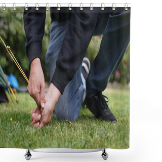 Personality  Close Up Of Male Hands Pegging Down A Tent On Grass. Pitching A Tent With A Stake. Shower Curtains
