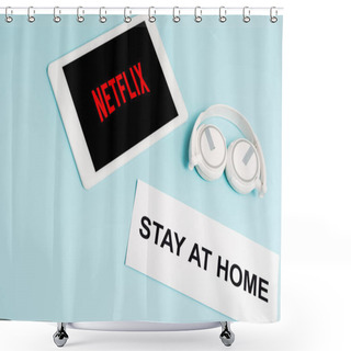 Personality  KYIV, UKRAINE - APRIL 8, 2020: Digital Tablet With Netflix App Near Headphones And Paper With Stay At Home Lettering On Blue  Shower Curtains