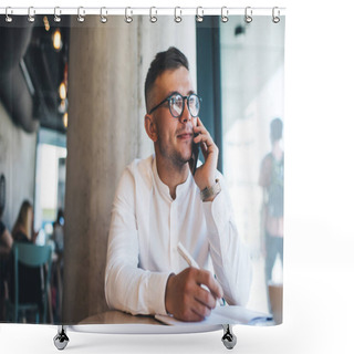 Personality  Focused Young Male Freelancer Wearing White Shirt And Eyeglasses Writing Notes During Phone Call While Working Remotely In Creative Cafeteria Shower Curtains