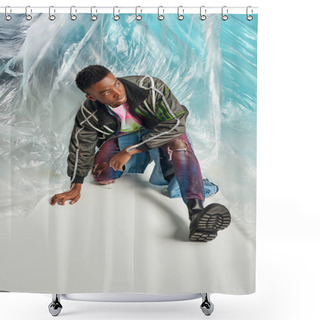 Personality  Confident African American Model In Outwear Jacket With Led Stripes And Ripped Jeans Looking Away Near Glossy Cellophane On Turquoise Background, Urban Outfit And Modern Pose, DIY Clothing  Shower Curtains