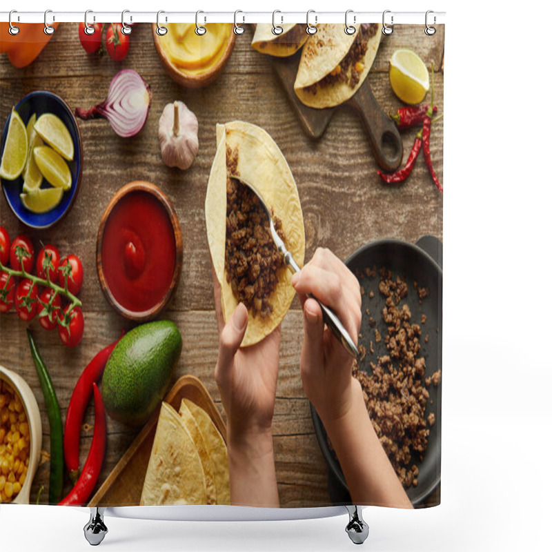 Personality  Cropped view of man adding minced meat in taco with raw ingredients on wooden surface shower curtains