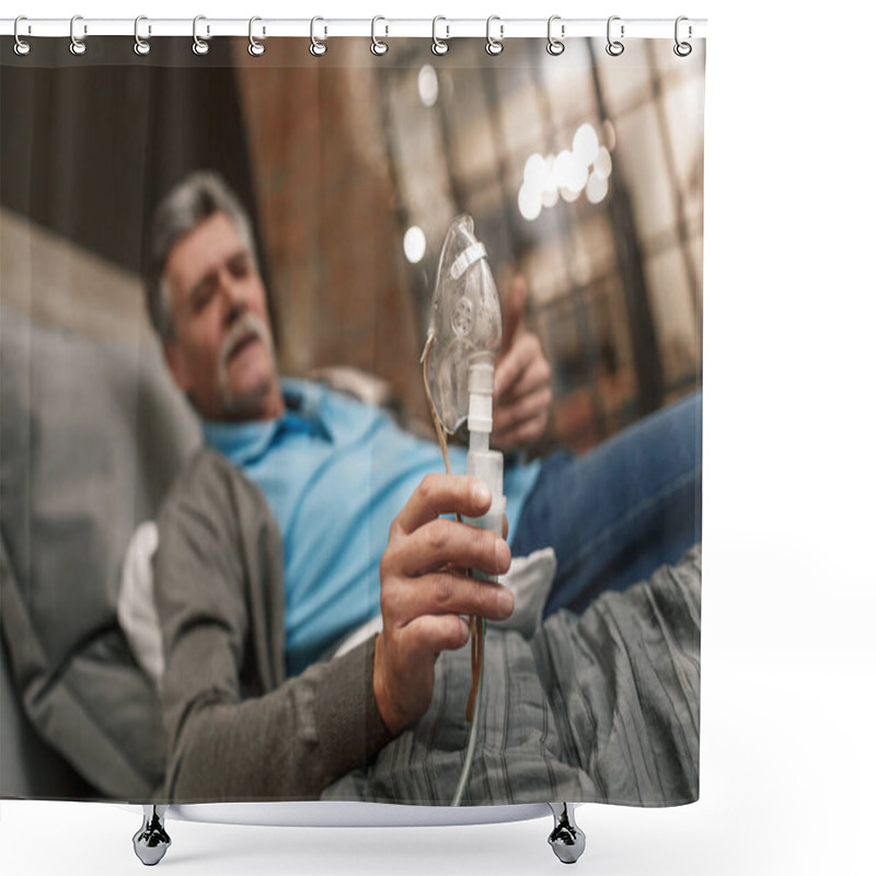 Personality  Portrait of old male holding inhalation through oxygen mask at home bedroom and use his laptop. shower curtains