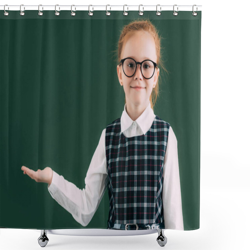 Personality  adorable little schoolgirl in eyeglasses showing blank chalkboard and smiling at camera  shower curtains