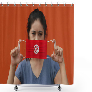 Personality  A Woman With Tunisia Flag On Hygienic Mask In Her Hand And Lifted Up The Front Face On Orange Color Background. Tiny Particle Or Virus Corona Or Covid 19 Protection. Concept Of Combating Illness. Shower Curtains