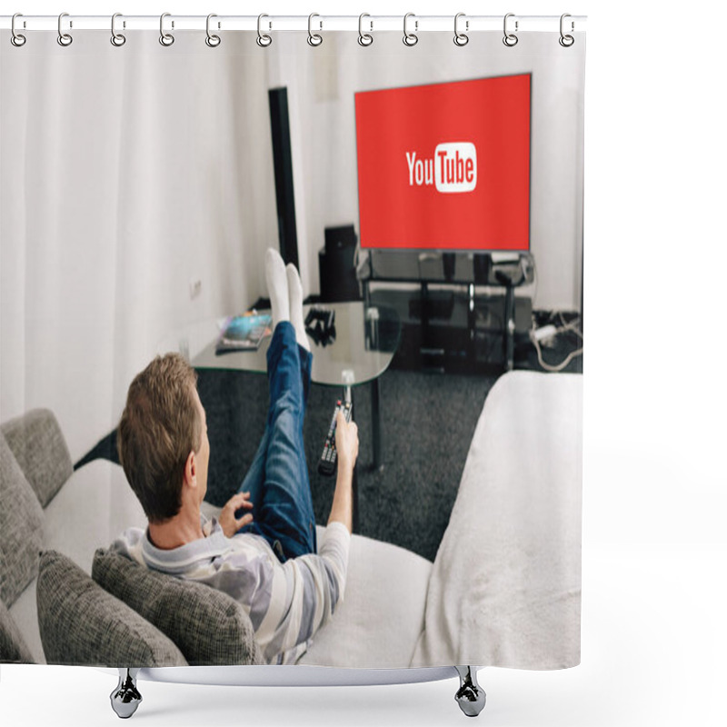 Personality  KYIV, UKRAINE - APRIL 14, 2020: man in jeans holding remote controller near tv screen with youtube at home  shower curtains