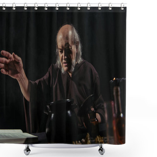 Personality  Mysterious Alchemist With Outstretched Hand Near Pot And Magic Cookbook Isolated On Black Shower Curtains