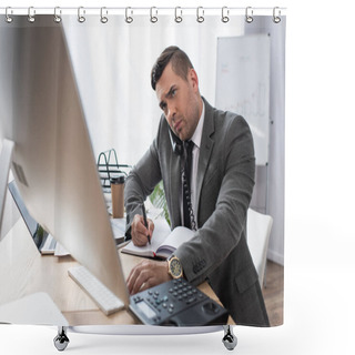 Personality  Concentrated Trader Looking At Computer Monitor, Talking On Telephone And Writing In Notebook, Blurred Foreground Shower Curtains