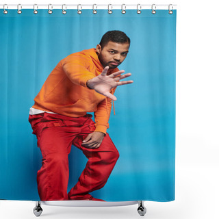 Personality  Attractive African American Man In Vibrant Outfit Hiding From Camera With Hand On Blue Background Shower Curtains