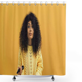 Personality  Young Hispanic Woman Holding Remote Controller Isolated On Yellow Shower Curtains