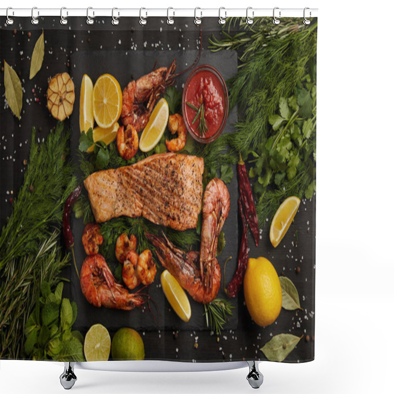 Personality  top view of grilled salmon steak, shrimps, pieces of lemon, sauce and spices on black surface shower curtains