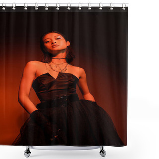 Personality  Confident Asian Woman With Wet Hairstyle Posing In Black Strapless Dress With Tulle Skirt And Gloves While Standing On Dark Orange Background With Red Lighting, Golden Jewelry, Young Model Shower Curtains