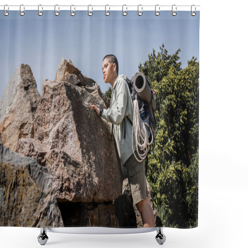 Personality  Young tattooed and short haired female tourist with backpack and travel equipment touching stone and looking away while standing with nature at background, exploring new horizons, summer shower curtains