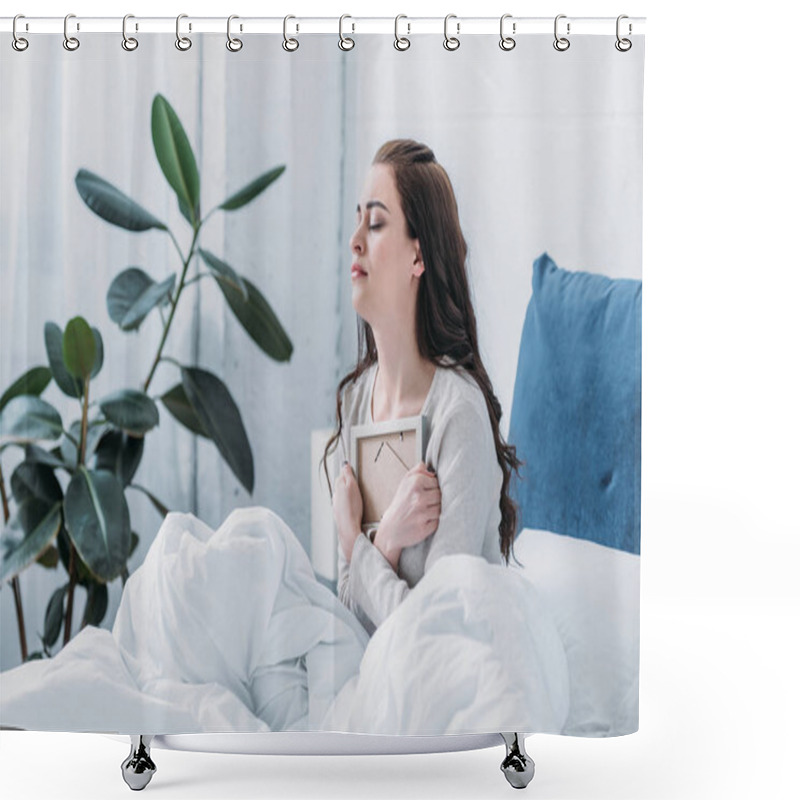 Personality  grieving woman with eyes closed in bed holding picture frame at home shower curtains