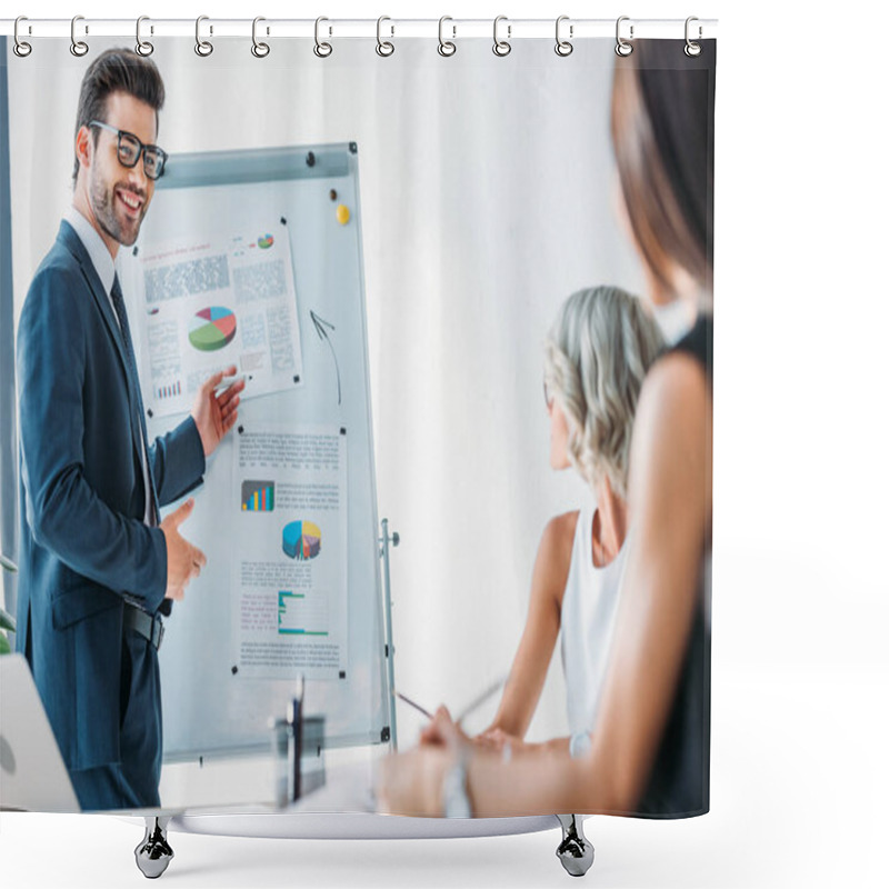 Personality  smiling businessman pointing on flipchart during presentation for businesswomen in office shower curtains