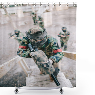 Personality  High Angle View Of Paintball Player Aiming By Marker Gun And Running On Staircase While His Team Standing Behind Outdoors  Shower Curtains