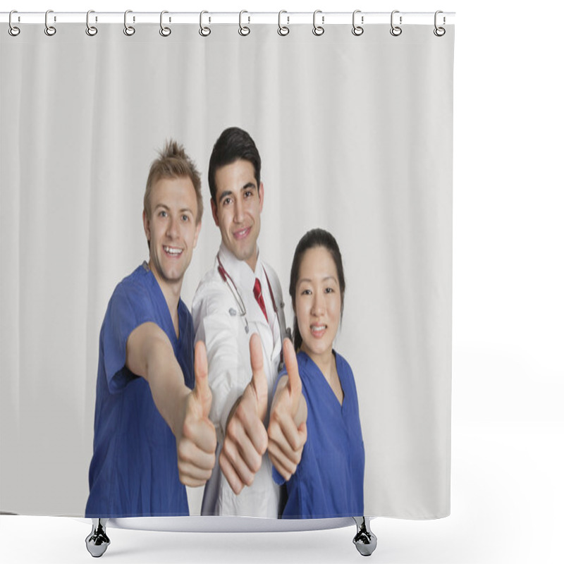 Personality  Portrait of a happy medical team gesturing thumbs up over gray background shower curtains