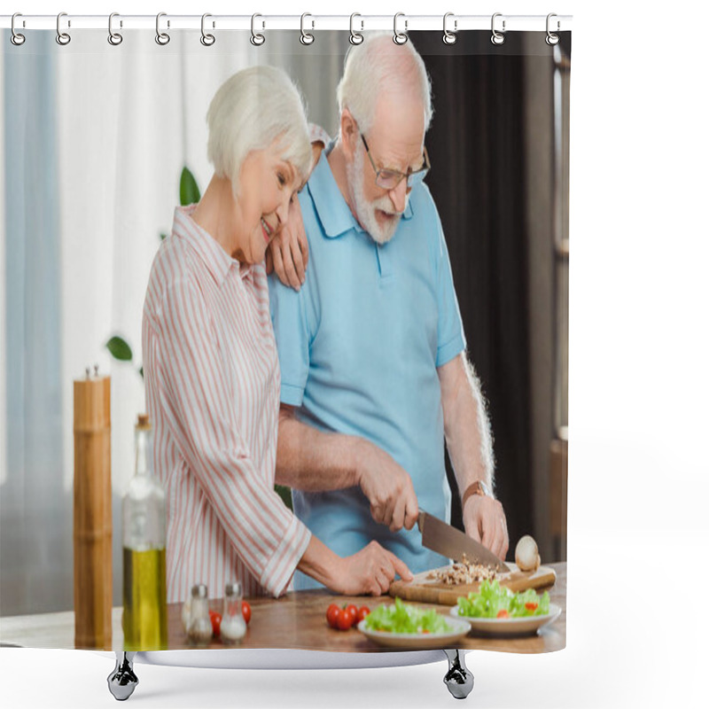 Personality  Smiling senior woman standing by husband cutting vegetables on kitchen table  shower curtains