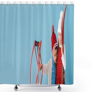 Personality  Horizontal Image Of Children In Winter Outfit Holding Skis And Sleight While Hugging Isolated On Blue  Shower Curtains